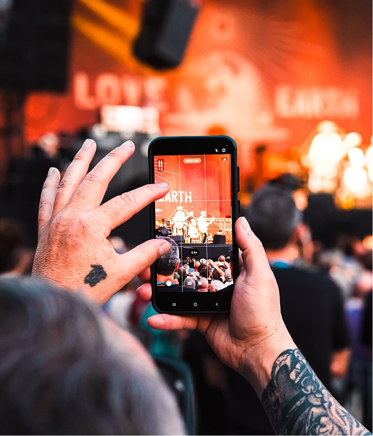 Photo d'une personne qui prend en photo un spectable géré par Rock The City